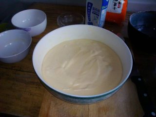 10、夹心水果派-健康蒸蛋糕,另外找个大器皿，将剩下一半的黄油均匀涂抹在器皿内部。然后倒入搅拌好的蛋液，用勺子将表面尽量抹平