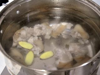 5、花生炖猪蹄,换一盆清水，放入姜片，重新烧开，小火慢炖。