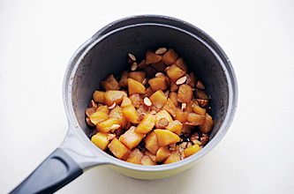 8、圣诞平安派（苹果派）,再次开火加入苹果块，香草荚刮出香草籽与香草荚一同放入锅中，中小火熬煮至汤汁浓稠，苹果变软后关火，加入杏仁和朗姆酒拌匀待用