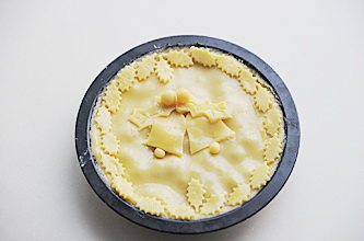 12、圣诞平安派（苹果派）,再将剩余的派皮擀成3mm左右厚，铺在派馅上，用刮板刮掉多余的派皮，表面刷一层蛋黄液，将多余的派皮刻成叶子状、铃铛等圣诞素材的装饰饼皮，贴在派顶部，烤箱预热200℃，中层烘烤20-25分钟，表面呈棕黄即可出炉，出炉后室温冷却切块享用