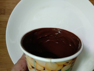 9、仿真早餐（芒果布丁+巧克力杯子）,一次性纸杯里倒入适量巧克力，快速转动杯子，让巧克力酱粘在杯壁上，放入冰箱冷藏15分钟。取出重新倒入巧克力酱，借助勺子把杯壁涂厚点，杯底巧克力也要厚，放入冰箱冷藏3小时（具体时间根据杯子大小调整）在油纸上画出杯把放入冰箱冷藏。