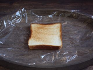 7、蒸烤鸡胸时蔬三明治（便携美食）,将一片面包切片放在塑料保鲜膜上。