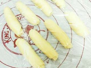 7、豆沙蛋黄酥,全部卷起后盖上保鲜膜松弛十五分钟