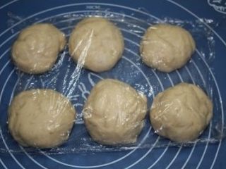 7、培根沙拉面包,将发酵好的面团分成六份，再滚圆，盖上保鲜膜松弛十分钟