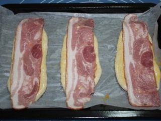 10、培根沙拉面包,将擀好的长条摆在烤盘上，刷上蛋液，摆上培根片