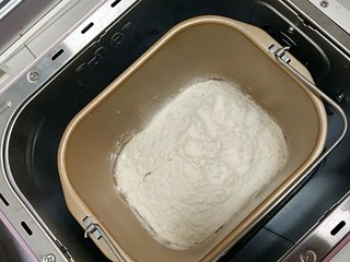 2、#宝宝辅食#奶香小馒头,将牛奶倒入面包机，面粉均匀的撒在牛奶上，酵母埋在面粉中，启动和面功能，和面10分钟