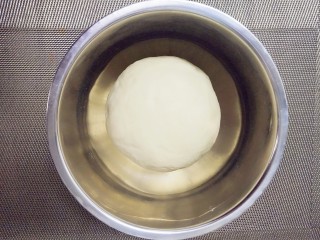 3、#宝宝辅食#奶香小馒头,揉至光滑不沾手的面团，放入容器中，盖上保鲜膜，放在烤箱或者温度高的地方，发酵至两倍大，即可，大约一个小时左右