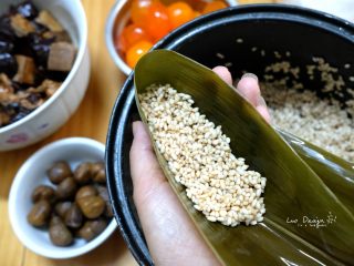 2、吉祥三宝粽（咸蛋黄 五花肉 栗子）,铺入适量糯米。