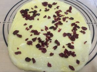6、蔓越梅手撕面包,将炼乳黄油液刷在面饼上，撒上切碎的蔓越梅。