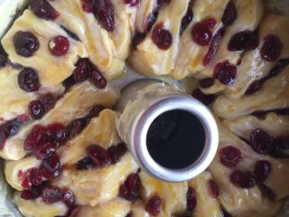 9、蔓越梅手撕面包,将面胚竖着码放在模具中，盖保鲜膜第二次发酵。发酵两倍大时刷蛋液，再在上面撒蔓越梅和杏仁片。