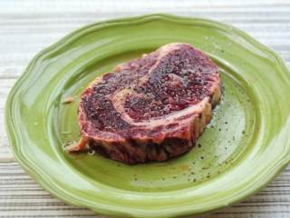 2、黑椒煎牛排,在牛排表面撒少许盐抹匀，再撒上现磨的黑胡椒，最后抹上一层橄榄油腌10分钟。