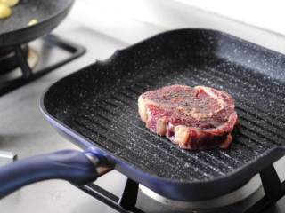 5、黑椒煎牛排,牛排锅烧热，一定要烧热哦，放入牛排不要动，大约一分钟后将牛排旋转70度，再煎一分多钟后翻面。