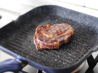 6、黑椒煎牛排,翻面后和之前一样，先煎一分多钟，期间不要动牛排，待烫出花纹后再旋转一下再煎一分多钟。煎的时间在5分钟左右。如果牛排比较薄，要适当缩短时间。