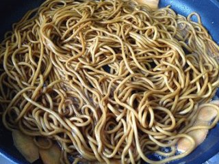 5、黯然销魂炒面,平底不粘锅(如果是普通炒锅,要热锅后加冷油随即放入面条翻炒才不容易粘锅)加一勺芝麻油中火加热,放入胡萝卜炒香后倒入面条,用筷子不断拔翻;