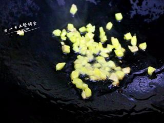 3、南瓜焖饭,把油倒入锅中，在温热的时候加入姜粒，中火炒香，炒至微焦。