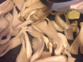 3、清炒平菇,如图用小火化猪油 爆香姜片在下平菇翻炒转小火