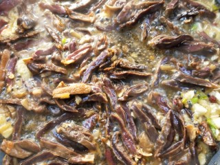 17、美味酸萝卜炒腊鸭心,倒入蒸熟的腊鸭心翻炒一下，接着把蒸腊鸭心的汁倒进去继续翻炒。