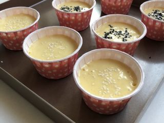 12、无水蜂蜜小蛋糕,撒上芝麻，轻震两下，震掉大气泡