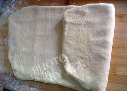 6、酥皮,用擀面棍轻轻敲打表面，再擀成薄片，从1/3外向中间折。