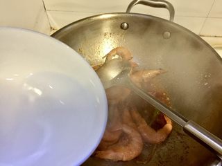 21、恨不能吮手指的好味➕茄汁油焖大虾,加入小半碗温水，用锅铲轻轻按压虾头让虾脑渗出，可以使味道更加鲜美