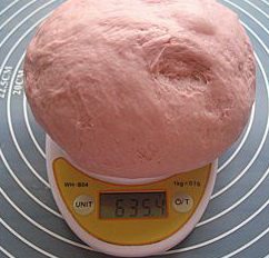 9、紫薯红豆沙吐司,发酵好的面团轻轻揉至排尽气体，上称。