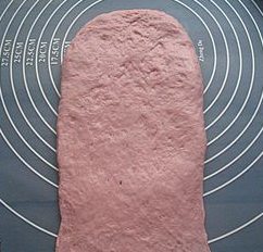 11、紫薯红豆沙吐司,15分钟后，面团擀开，翻面，压薄底边。