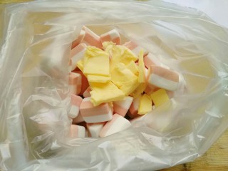 5、花生高钙牛轧糖,厚保鲜袋放入棉花糖和黄油，口扎紧，微波炉高火1分钟