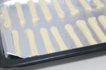 8、手指饼干,装入裱花袋,用中号圆形裱花嘴在烤盘上挤出长条形,烤箱预热190度,中层,约10分钟上色即可。