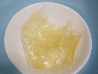 9、镜面芒果慕斯蛋糕,吉利丁片沥出多余水分，放在干净的容器中隔水融化成液体，倒入8中的拌好的芒果泥中充分搅拌，一定要搅拌均匀，不然慕斯会出水哦