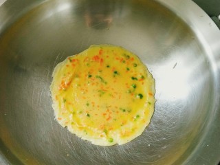 6、葱花鸡蛋饼,待一面凝固后翻转另一面