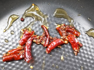 9、鲜香辣杏鲍菇炒腊肉,起油锅，小火放花椒粒，辣椒干煸炒出味。