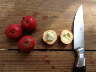 2、山楂糕,用水果刀沿山楂中间横切一圈,一分为二