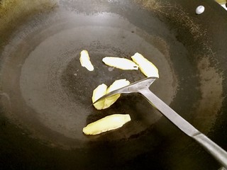8、豆腐鲫鱼汤,煮豆腐的时候来煎鱼。煎锅里放入姜片,用锅铲压着姜片滑动,滋一下锅。