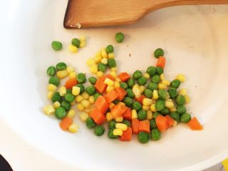 3、迷你小披萨,再放入豌豆、玉米粒、胡萝卜丁中火煸炒2分钟左右,可稍稍加点盐调味(可不加)。