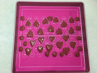 23、形彩绘芒果蛋糕卷,将裱花袋中的红曲粉蛋糕糊挤在彩绘硅胶的图案上,我这次做的是心形的。