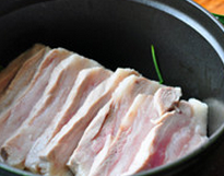 3、把子肉,将肉片整齐地铺在葱姜上