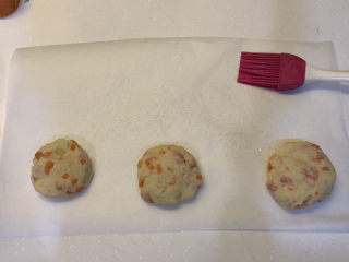 15、胡萝卜火腿肠土豆饼,怕粘住底部的话，就在纸下面擦上一层油，再依次铺上土豆饼