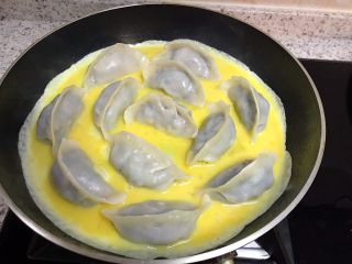 15、煎饺卧蛋,转动平底锅，让蛋液流动均匀，包裹住水饺