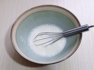 2、草莓蛋挞,将牛奶倒入器具中，加入奶油，用手动打蛋器打散。