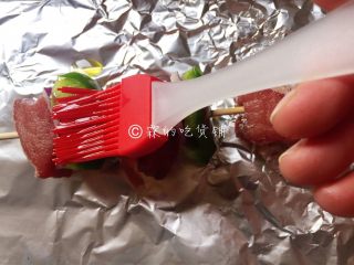 8、烤牛肉串,用刷子把牛肉串的前后左右都刷上一遍。