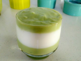 9、双层牛油果酸奶昔,再将牛油果奶昔倒入杯中最上层，可借助小勺，先将杯子四周倒入奶昔，再倒中间部分。