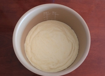 10、电饭煲版戚风蛋糕,将电饭煲插上电源，按下煮饭键预热3-5分钟，之后取出内胆锅。将上一步骤中办拌好的面糊倒入内胆锅内，在台面上轻磕几下，排下气。没有防粘功能的锅，提前在锅内图上点色拉油或者黄油。