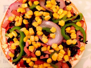 7、披萨????,将玉米粒铺上。????