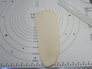 9、蔓越莓椰蓉面包卷,取一个面团，擀成牛舌状，稍微长一些，上端2厘米位置擀的薄一些，一会收口用。