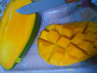 1、芒果流心慕斯,芒果切两半,取一半划八字刀,再一翻,把果丁切下来,同样方法切下另一半