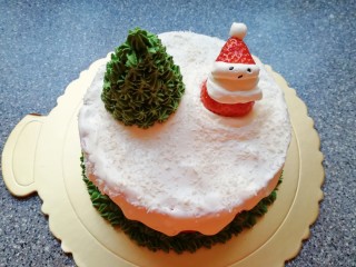 26、圣诞奶油蛋糕,将另外一颗草莓做一个圣诞老人放在蛋糕的另一边。具体做法是：草莓底部削平，从三分之二处切开，下半部分固定在蛋糕的另一边，做圣诞老人的身体，中间挤上白色的奶油，做圣诞老人的脸部，上半部分放在奶油上做圣诞老人的帽子，用黑芝麻做圣诞老人的眼睛和嘴。