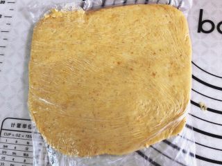 9、    宝宝辅食之补钙小零食—�虾条饼干,放在保鲜袋里，擀开，放冰箱冷冻20分钟。