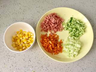 1、百变鸡蛋+福袋饭, 把胡萝卜和黄瓜洗净去皮，切碎，西兰花洗净切碎，火腿肠切碎，玉米煮熟，剥粒。