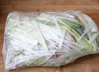 4、孜然烤羊腿,然后两面都用葱姜丝铺满，用保鲜膜包好，进行腌制，一定要腌制24小时以上才能入味