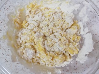 3、果干沙琪玛,蛋液分次加入混合好的面粉中，用筷子挑拌成絮状。